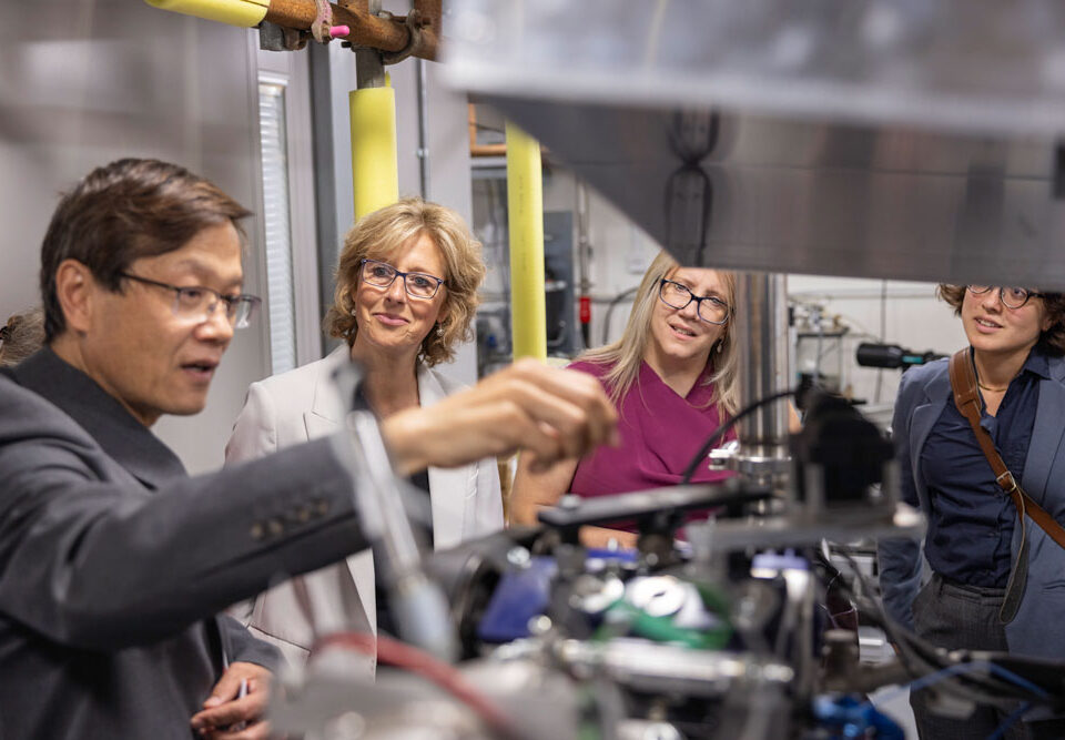 Academics discussing clean hydrogen engines in a lab or workshop setting.